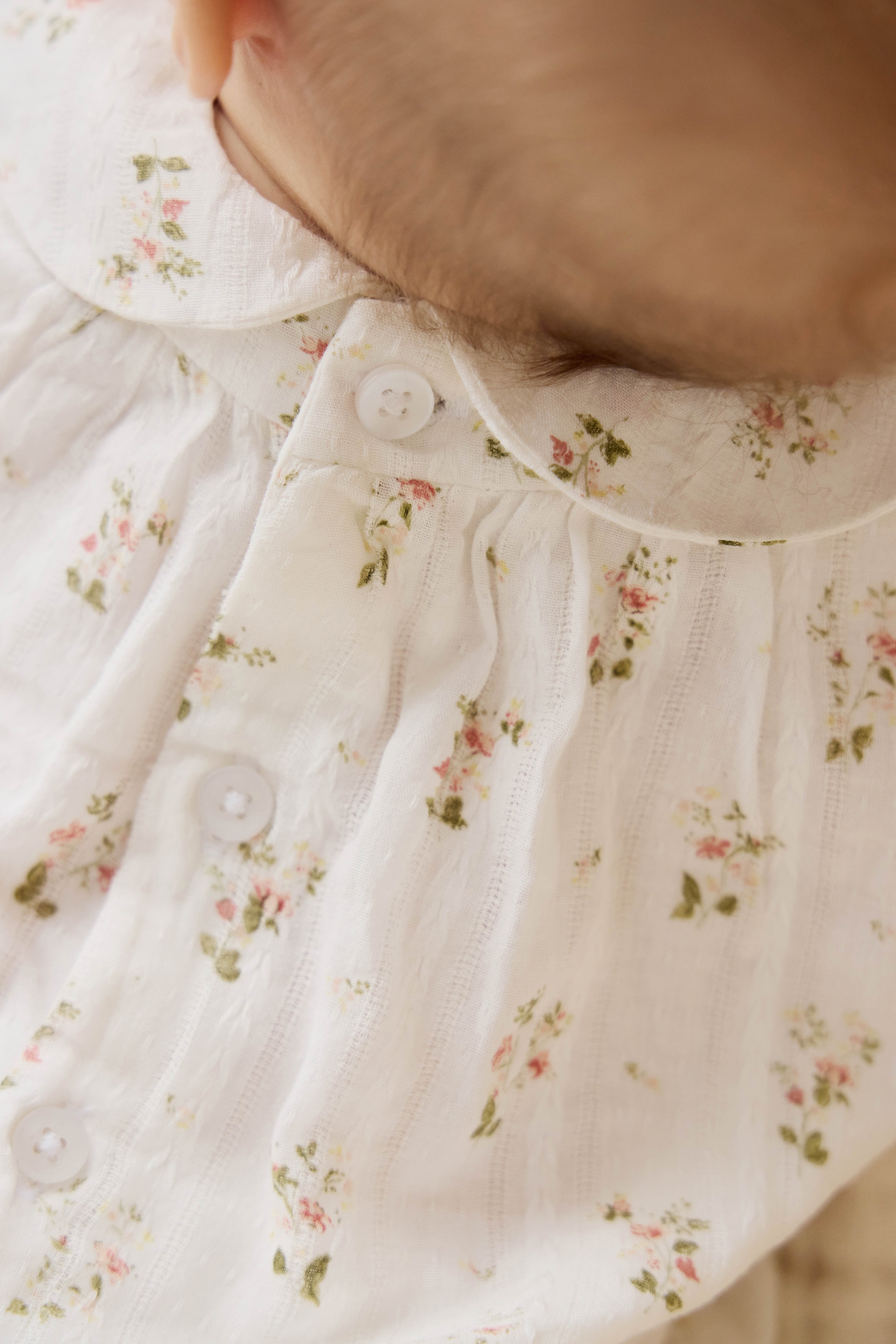 Barboteuse vintage en coton bio blanc à imprimé floral, col Claudine et jambes élastiquées