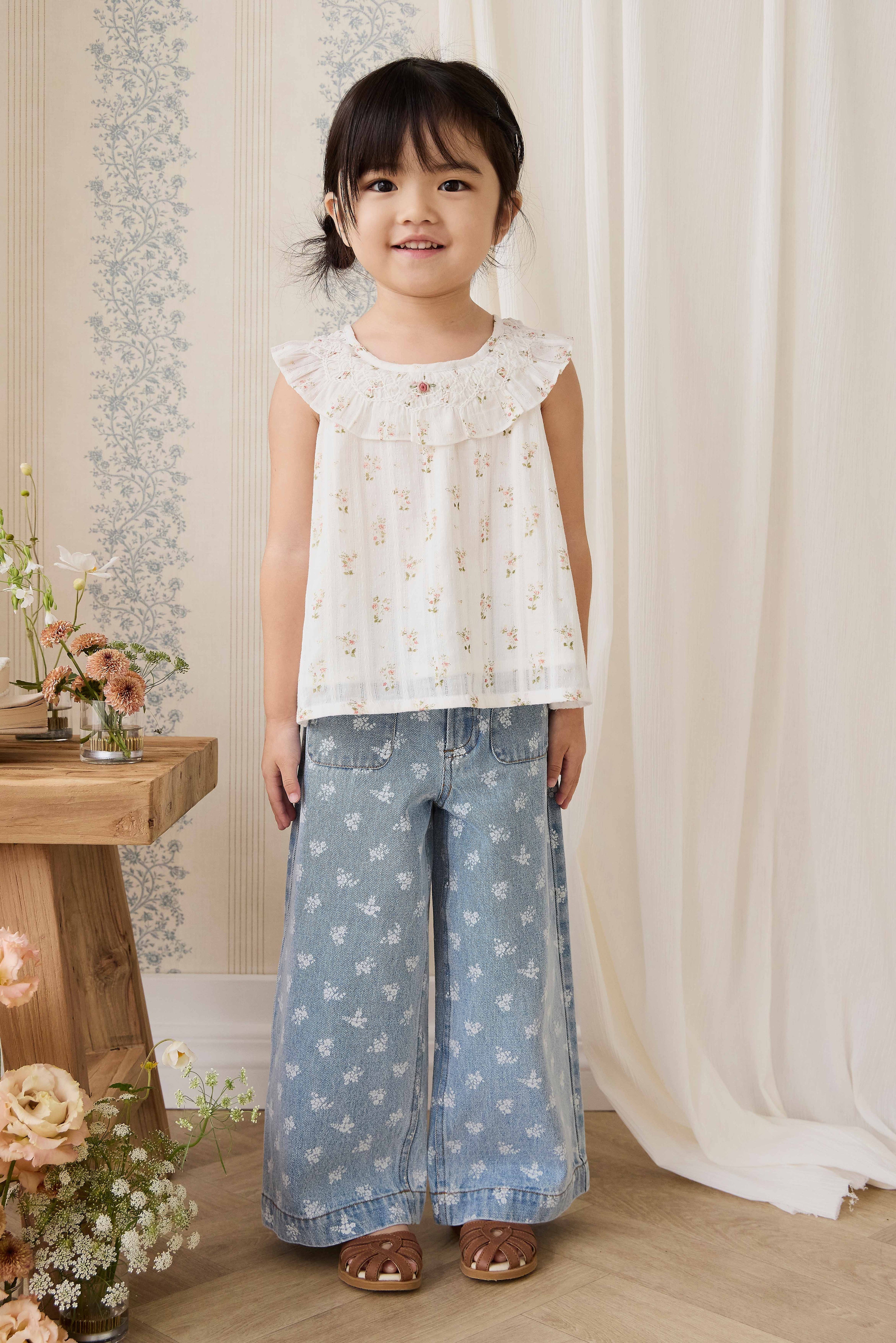 Haut en coton biologique blanc à imprimé floral vintage avec encolure à volants et manches courtes.
