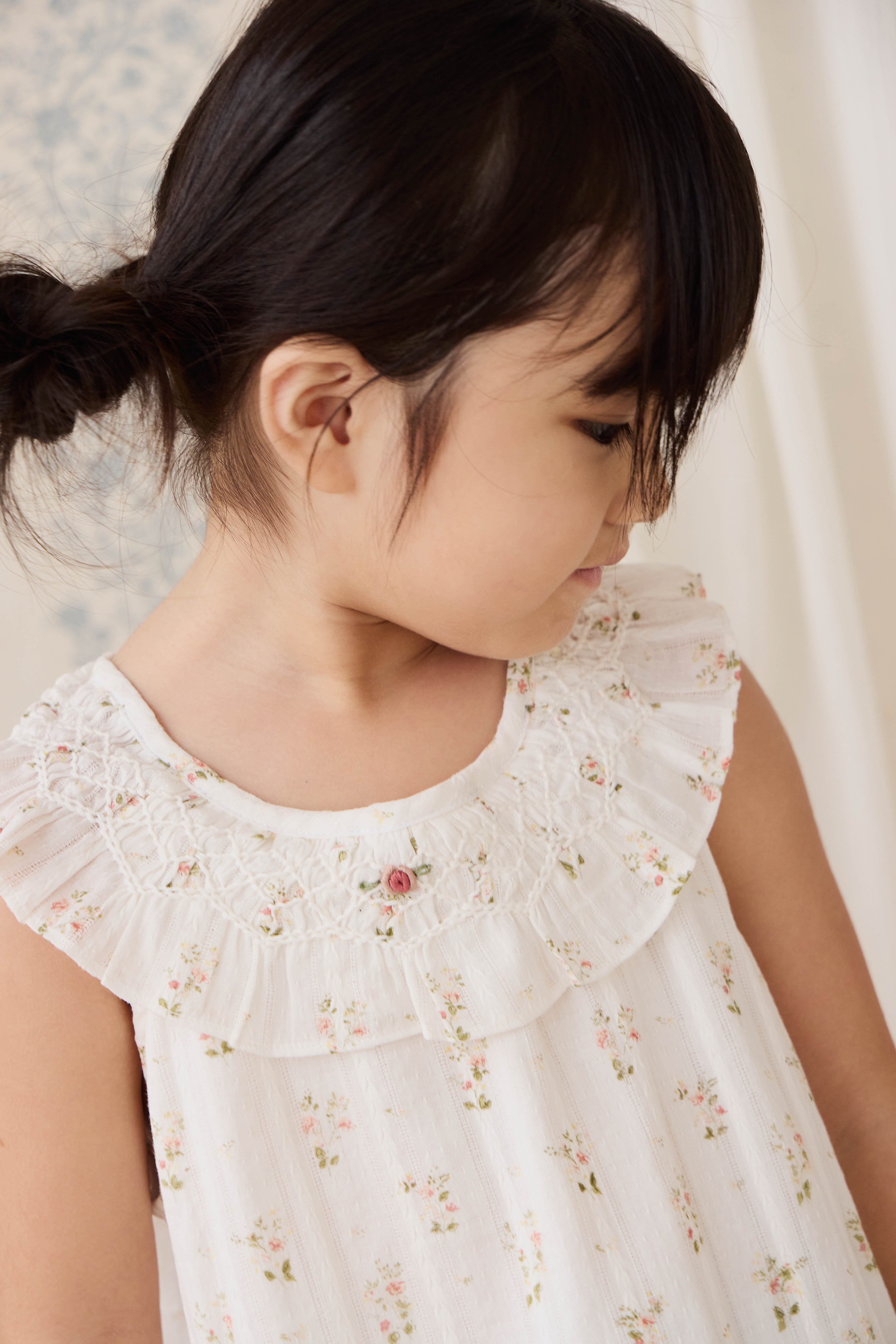 Haut en coton biologique blanc à imprimé floral vintage avec encolure à volants et manches courtes.