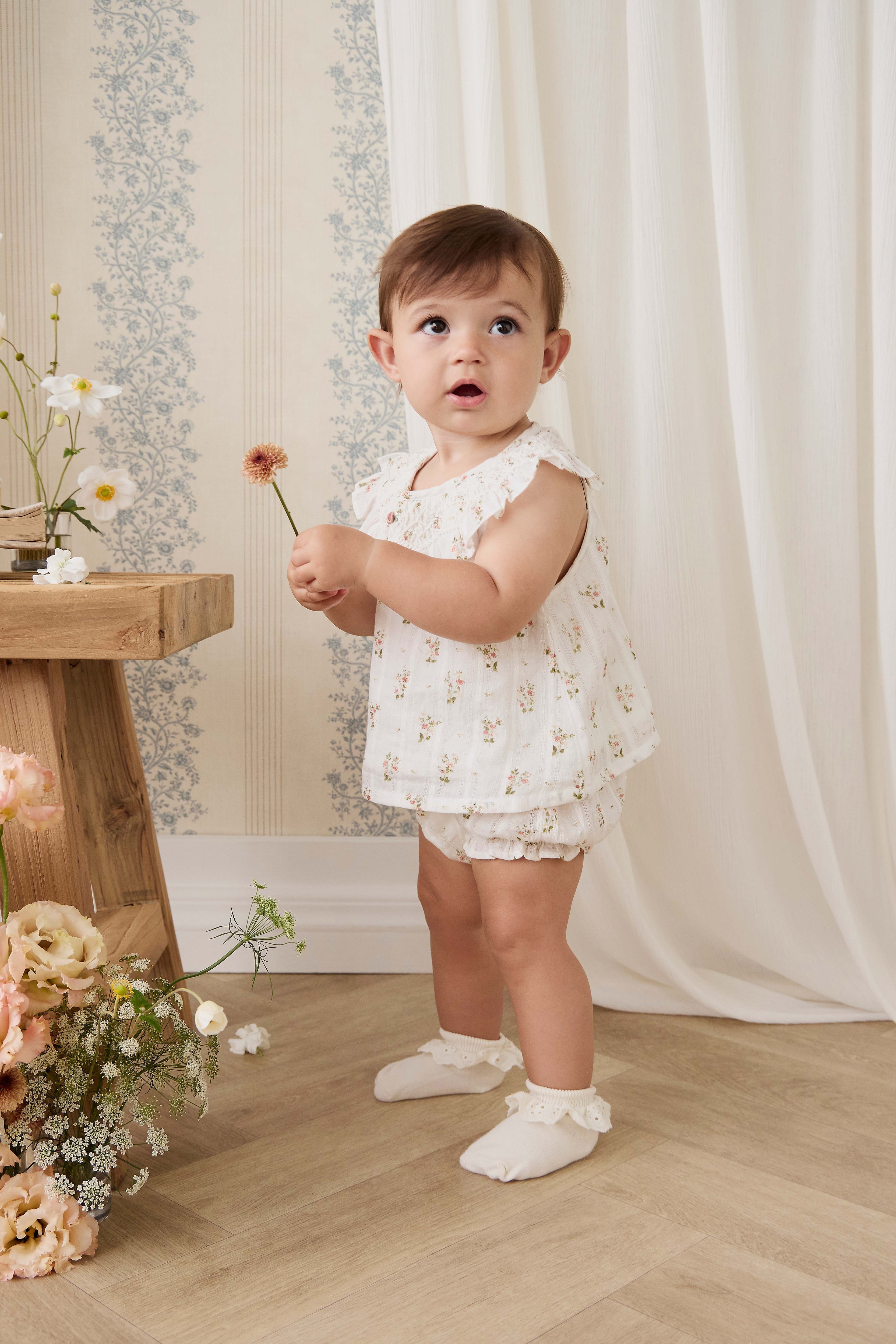 Haut en coton biologique blanc à imprimé floral vintage avec encolure à volants et manches courtes.
