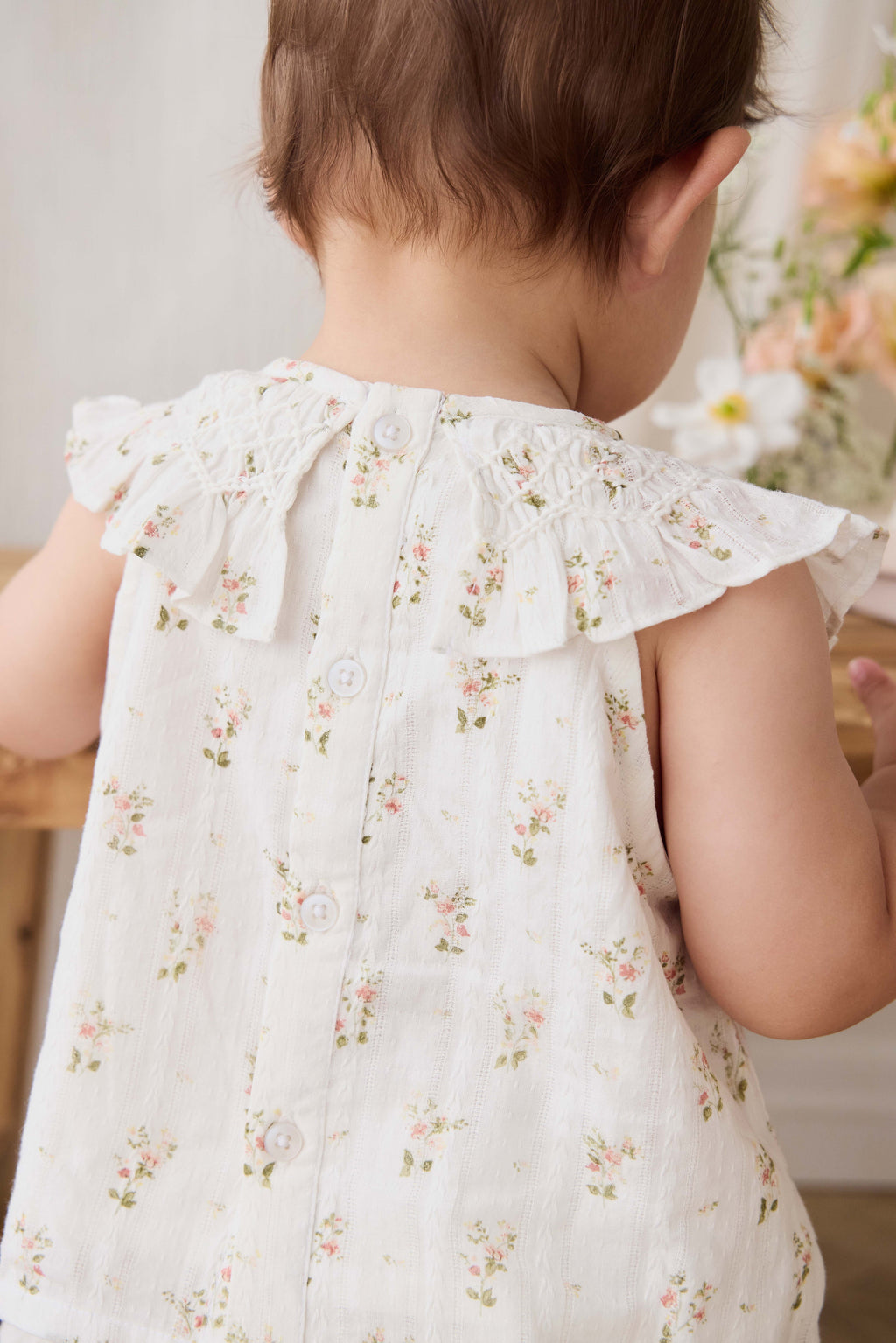 Haut en coton biologique blanc à imprimé floral vintage avec encolure à volants et manches courtes.