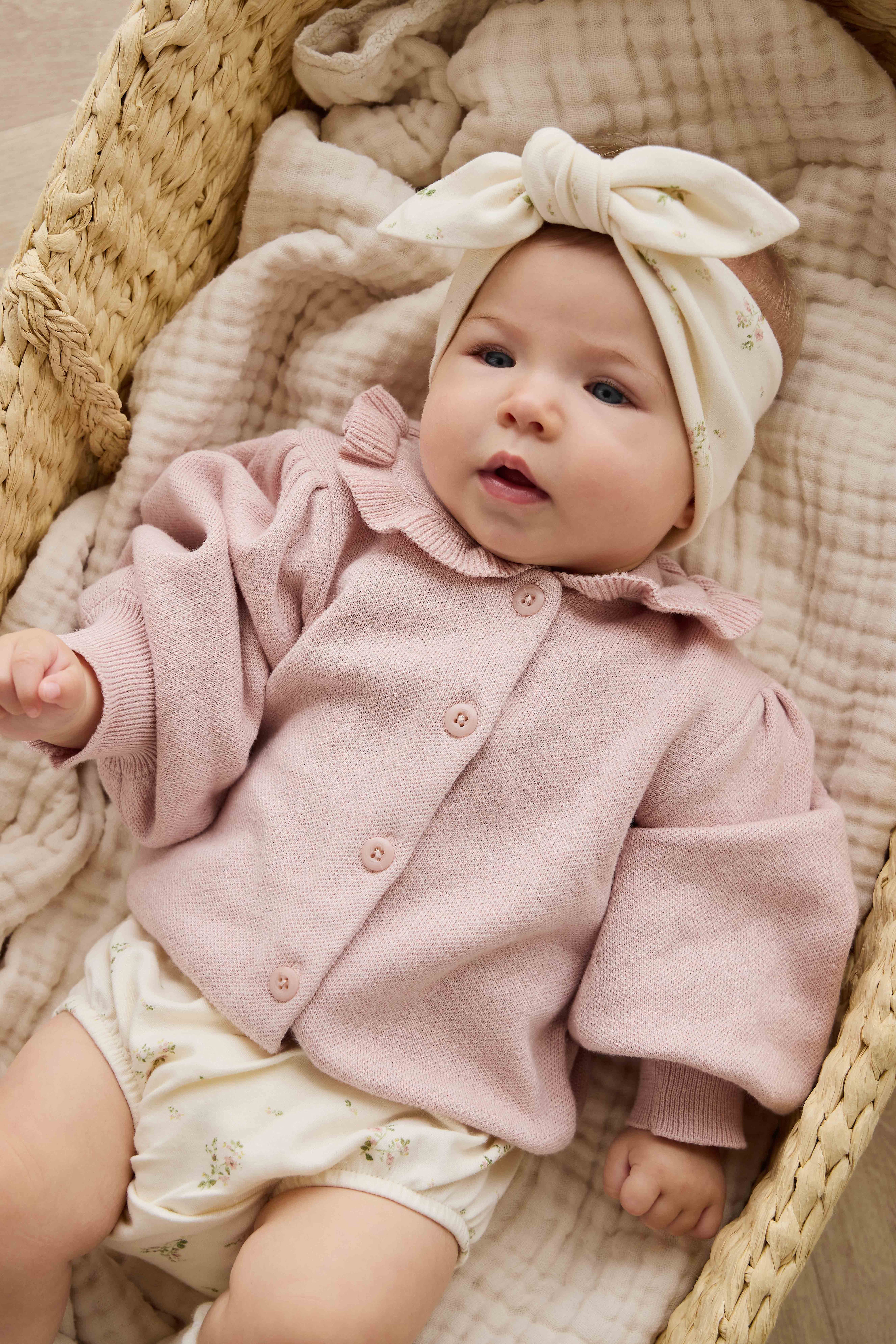 Gilet en maille de coton rose pêche avec col à volants et manches bouffantes